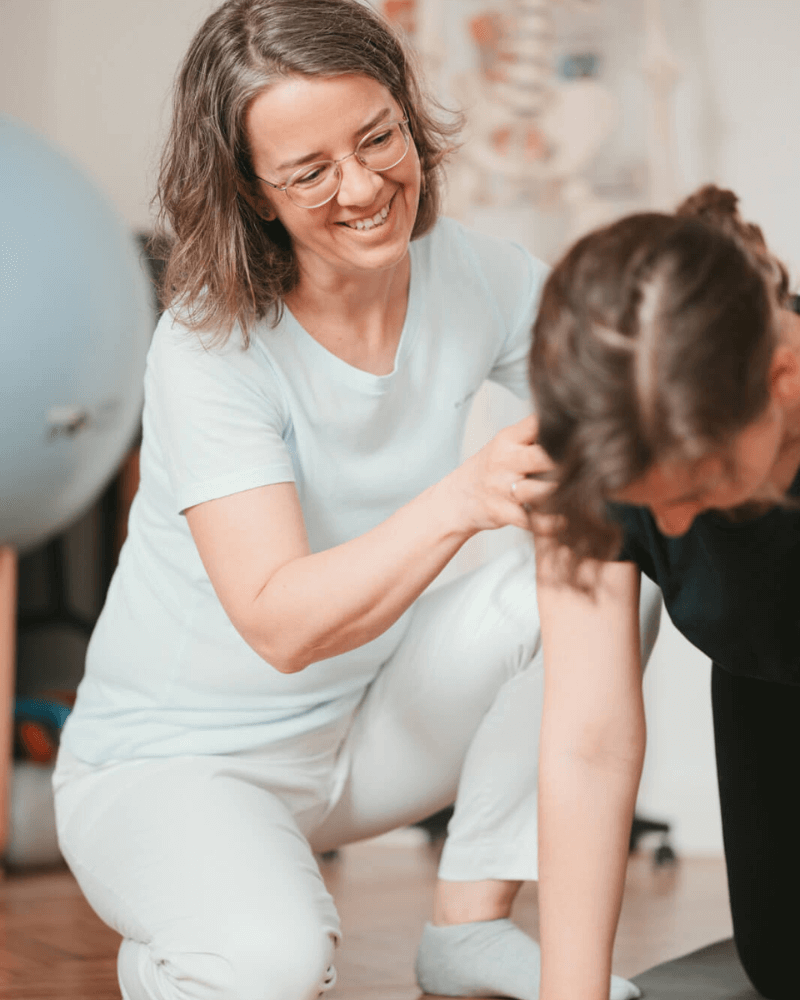 Physiotherapeutin zeigt Rückbildungsübungen für Frauen nach der Geburt in Gerasdorf bei Wien